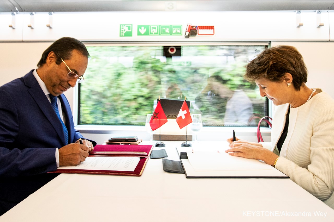 La conseillère fédérale Simonetta Sommaruga et le ministre marocain des transports Abdelkader Amara signent la déclaration d'intention lors d’un voyage en train en commun.